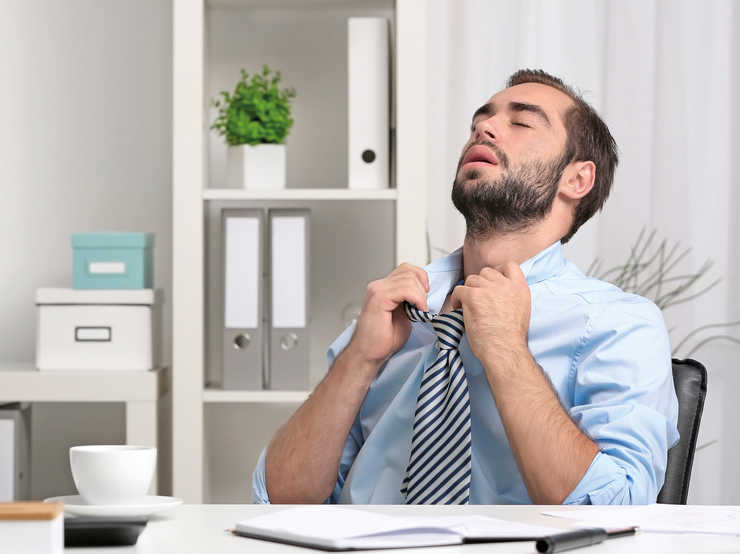 Un homme ouvre le col de sa chemise