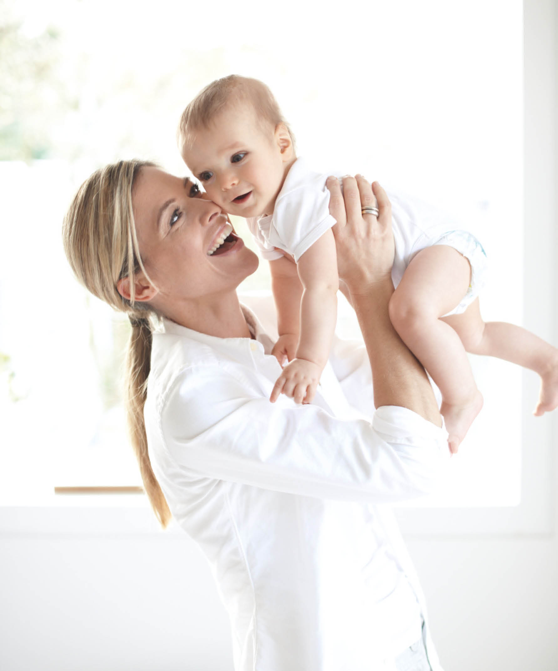 Frau mit Baby vor Fenster